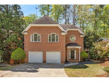 Charming two-story brick home featuring a two-car garage and well-manicured landscaping at 1020 Burton Ne Dr, Atlanta, GA 30329