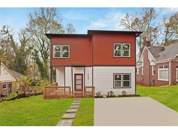 Modern two-story home boasts a red and white exterior, inviting front porch, and well-manicured lawn at 2166 Belvedere Sw Ave, Atlanta, GA 30311