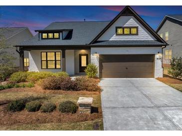 Charming single-Gathering home featuring a two-car garage, attractive landscaping, and classic white painted brick at 348 Ellington Dr, Canton, GA 30115
