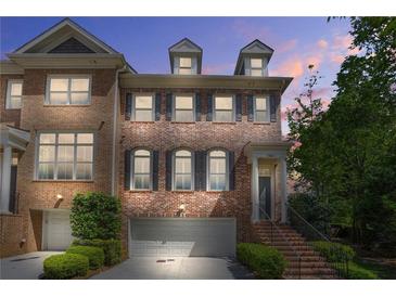 Charming brick townhome with manicured landscaping and attached garage, perfect for modern living at 1561 Mosaic Way, Smyrna, GA 30080