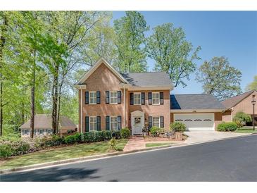 Charming two-story brick home with black shutters and a well-manicured lawn surrounded by lush trees at 1826 Bedfordshire Ct, Decatur, GA 30033