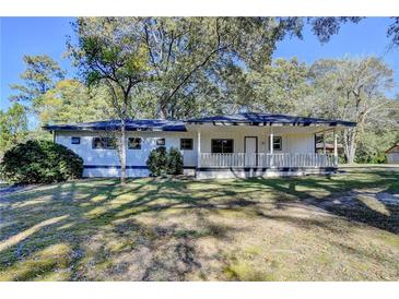 Inviting single-story home with a covered front porch and lush green lawn, perfect for relaxation at 21 W Lake Dr, Oxford, GA 30054