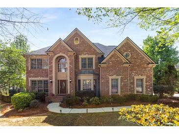 Charming two-story brick home with manicured landscaping and mature trees on a sunny day at 482 Cooper Lake Se Rd, Smyrna, GA 30126
