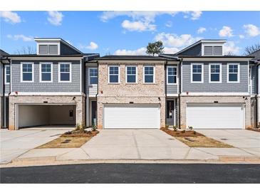 New townhome with brick and siding, featuring attached garages and professional landscaping at 1016 Rose Dr, Marietta, GA 30060