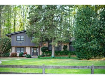 Charming two-story home featuring mature trees, well-manicured lawn and beautiful landscaping at 1039 Smyrna Rd Sw, Conyers, GA 30094