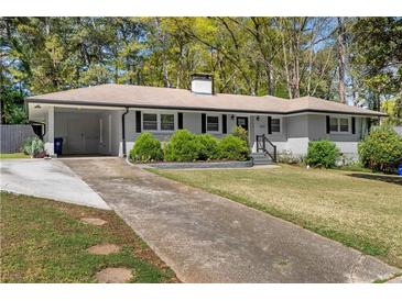 Charming single-story home with a manicured front lawn and attached carport in a wooded neighborhood at 2123 Juanita St, Decatur, GA 30032