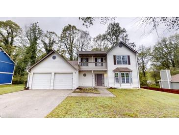 Two-story home with a two-car garage, balcony, and manicured front lawn at 2740 Ashley Downs Ln, Atlanta, GA 30349