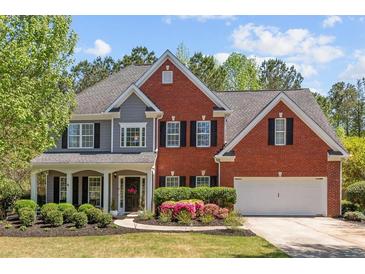 Charming two-story home with brick and gray siding, manicured lawn, and a welcoming front porch at 4013 Suwanee Place Dr, Suwanee, GA 30024