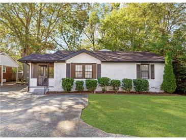 Charming white brick home with a well-manicured lawn and lovely landscaping at 1340 Hawthorne Se Ave, Smyrna, GA 30080