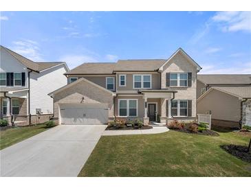 Charming two-story home featuring a two-car garage, manicured lawn, and inviting front porch at 2770 Westgate Park Dr, Loganville, GA 30052
