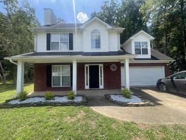Charming two-story home featuring a brick and vinyl exterior and a well-manicured lawn at 3870 Spring Moss Cir, Snellville, GA 30039