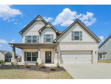 Charming two-story home with white brick, gray siding, covered porch, and a two-car garage at 3002 Blue Stone Ct, Dacula, GA 30019