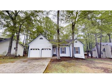 Charming single-story home featuring a two-car garage and a well-maintained front yard with mature trees at 3979 Sharon Spgs, Powder Springs, GA 30127