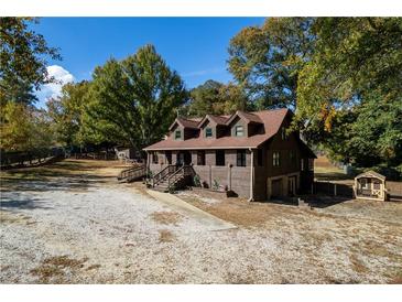 Charming wood home featuring a lovely front porch and ample space for parking and recreation at 5098 Meadows Rd, Powder Springs, GA 30127