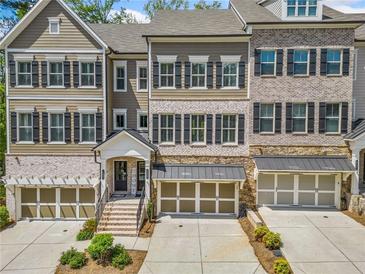 Beautiful townhome with a two-car garage, complemented by a meticulously landscaped front yard at 815 Paden St, Woodstock, GA 30188