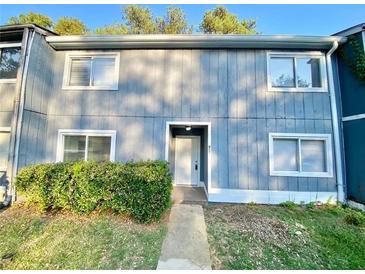Two-story exterior of townhouse with a walkway, bushes, and windows at 927 Pine Oak Trl, Austell, GA 30168
