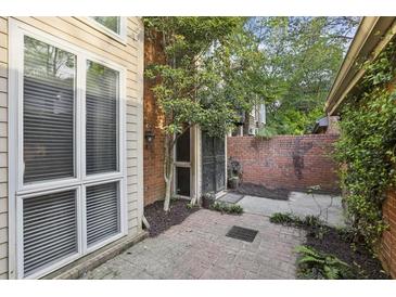 Private brick courtyard featuring mature trees and access to the home at 45 Willow Ne Gln, Atlanta, GA 30342