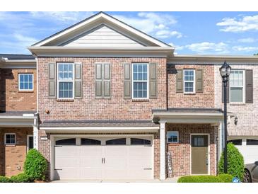 Charming brick townhome with a welcoming two-car garage and well-maintained landscaping at 216 Ellis Ln, Woodstock, GA 30189