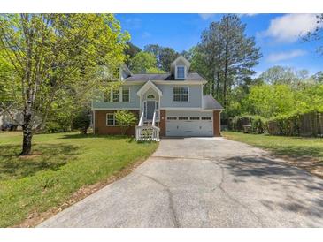 Charming two-story home with landscaped yard and a two-car garage and long driveway on a sunny day at 3898 Hadley Farm Dr, Marietta, GA 30066