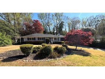 Charming single-story home featuring a manicured lawn and mature landscaping with vibrant, established trees at 4519 Sims Ct, Tucker, GA 30084