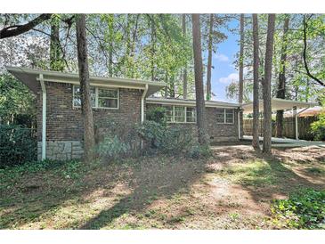Brick home featuring a carport, situated among trees at 2480 Warwick Ne Cir, Atlanta, GA 30345
