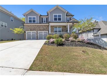 Charming two-story home featuring a stone facade, two-car garage, and a beautifully landscaped front yard at 5382 Pebblebrook Se Ln, Mableton, GA 30126