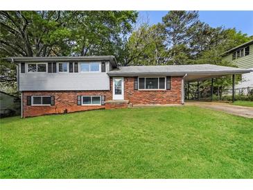 Charming brick home with a well-maintained lawn and carport offers classic curb appeal at 6497 King William Dr, Morrow, GA 30260