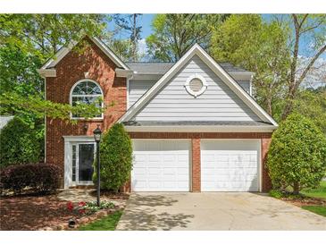 Charming two-story home featuring a brick facade, gray siding, and a two-car garage at 1433 Chardin Dr, Marietta, GA 30062