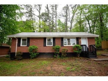 Charming brick home featuring a metal roof and freshly painted trim at 4322 Glenwood Pkwy, Decatur, GA 30032