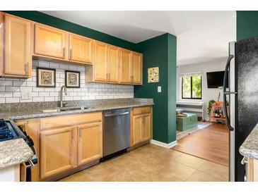 Well-lit kitchen with stainless steel appliances, granite countertops, light brown cabinetry, and a subway tile backsplash at 1355 Euclid Ne Ave # 15A, Atlanta, GA 30307