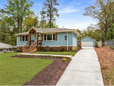 Charming light blue home with lovely landscaping, craftsman details, and a detached two-car garage at 2374 Marion Cir, Decatur, GA 30032