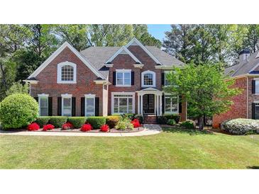 Beautiful brick home with manicured lawn and colorful flowerbeds at 3237 Birkdale Ave, Duluth, GA 30097