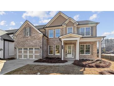 Charming brick two-story home with a two-car garage and covered entryway at 5827 Creek Indian Dr, Sugar Hill, GA 30518