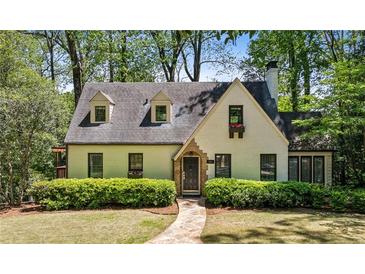 Charming home featuring a stone walkway, dormer windows, and lush landscaping at 1711 Homestead Ne Ave, Atlanta, GA 30306