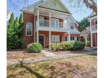 Charming two-story brick home featuring a covered porch and a well-maintained landscaped front yard at 392 Mill Pond Cossing, Carrollton, GA 30116