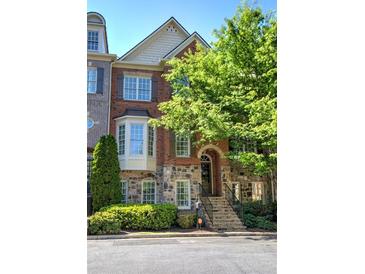 Charming brick and stone townhome with manicured landscaping and inviting entryway stairs at 636 Parkside Village Nw Way, Marietta, GA 30060