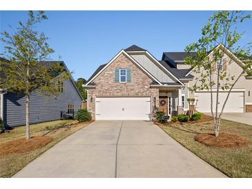 Charming home with a two-car garage, landscaped yard, and covered porch, set on a sunny day at 4565 Grenadine Cir, Acworth, GA 30101