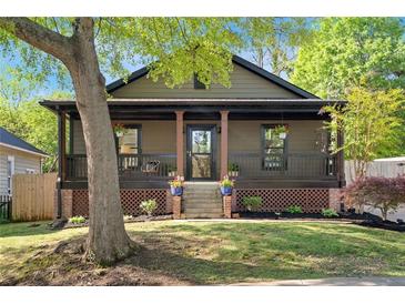 Charming home featuring a cozy front porch, lush lawn, and manicured landscaping at 1168 Eggleston Sw St, Atlanta, GA 30310