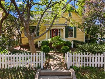 Charming two-story yellow home with a white picket fence and lush landscaping at 218 Barry St, Decatur, GA 30030