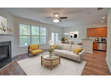 Bright living room featuring a fireplace, ceiling fan, and view of the outdoors at 2241 Nottley Dr # 4, Marietta, GA 30066