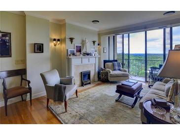 Bright living room with fireplace, hardwood floors, and large windows offering stunning views at 145 15Th Ne St # 1015, Atlanta, GA 30309