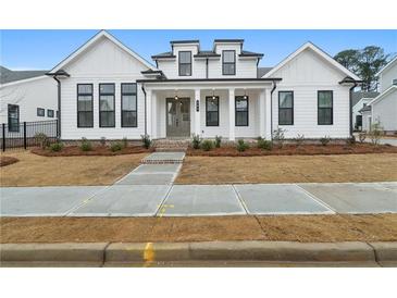 Charming two-story home with modern white siding, black trim, brick walkway, and fresh landscaping at 535 Pearl St, Cumming, GA 30040