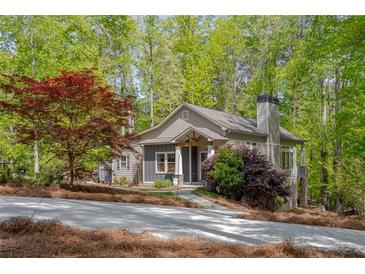 Charming home featuring a stone chimney and a landscaped front yard with mature trees at 803 Willow Oak Dr, Woodstock, GA 30189