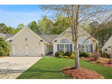 Charming home featuring a well-manicured lawn, a two-car garage, and large windows with blue shutters at 205 E Skyline Vw, Dallas, GA 30157