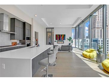 Bright living room with floor to ceiling windows and open layout to the kitchen area at 40 12Th Ne St # 903, Atlanta, GA 30309