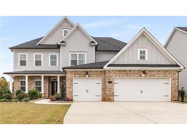 Beautiful two-story home features a brick and gray color scheme, two-car garage, and manicured lawn at 501 Blackberry Ln, Canton, GA 30115