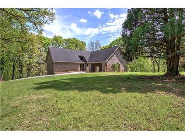 Charming brick home with a well-manicured lawn and mature trees, perfect for enjoying the outdoors at 5894 Highway 20 Ne, Cartersville, GA 30121