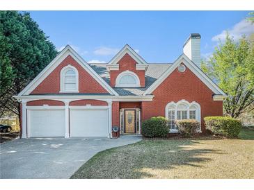 Charming two-story brick home with a well-manicured lawn and a two-car garage at 4505 Lakefield Bnd, Berkeley Lake, GA 30096
