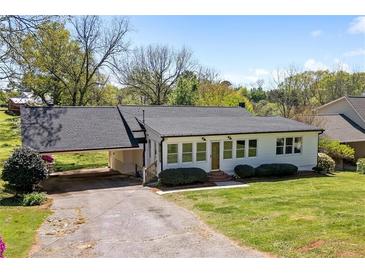 Charming single-story home with a covered carport and well-maintained front lawn at 313 Ellenwood Dr, Bowdon, GA 30108