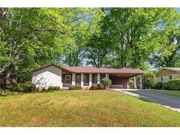 Charming one-story home with white brick, covered parking, and a lush green lawn at 3944 Woburn Dr, Tucker, GA 30084